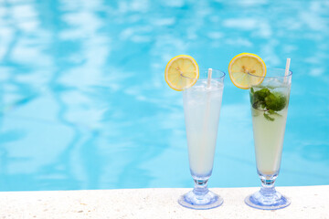 Two tropical cocktails near swimming pool