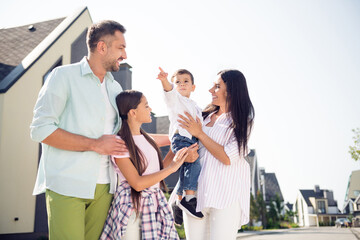 Photo of happy positive smiling cheerful family enjoying free time weekend go walk in street outside outdoors