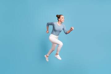 Fototapeta na wymiar Full size profile side photo of teenager cute girl jump run empty space isolated on blue color background