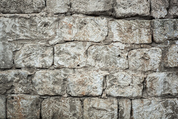 antique masonry wall with scuffs, rectangular blocks of gray beige color