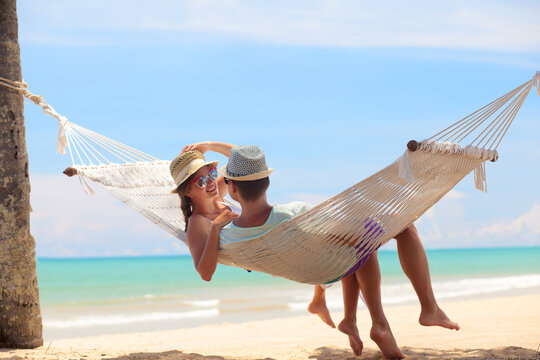 Young romantic couple relaxing in hammock on tropical beach in Thailand