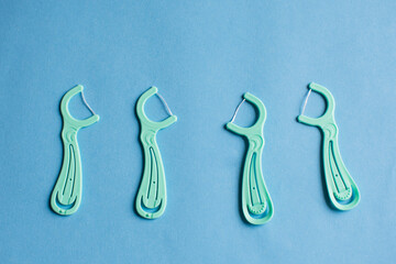 Dental floss in the row on blue background. Oral hygiene and helthy teeth and interdental space concept with copy space.