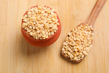 Unpolished Pigeon pea also known as toor dal in a metal bowl. Isolated on wooden background.