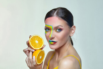 attractive girl holds orange slices in front of her face