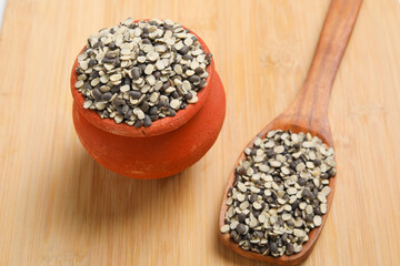 Split Black Lentil Also Know as Black Gram, Black Urad Dal, Vigna Mungo, Urad Bean on wooden background.