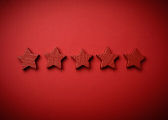 five red wooden stars on a red background