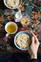 Rice pudding with milk, breakfast table with hand