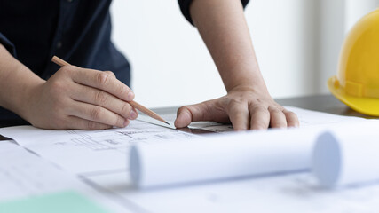 Architectural building design and construction plans with blueprints, Young man was designing a...