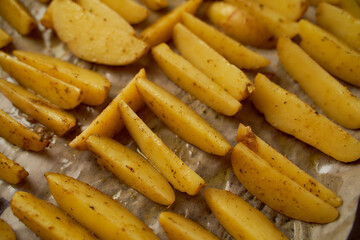Fresh potatoes cut into slices lies on a foil surface