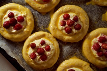 Homemade baking. Buns with cottage cheese and berries on a baking sheet