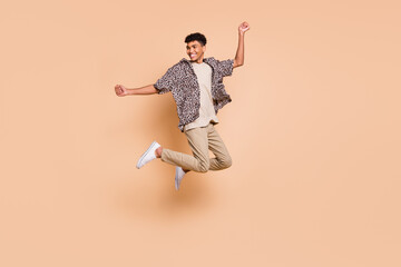 Fototapeta na wymiar Full size profile photo of brunet optimistic guy jump wear modern shirt pants isolated on beige color background