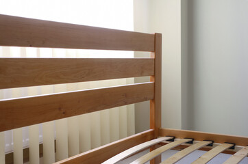 Fototapeta na wymiar frame of a simple lacquered bed made of wood with slats 
