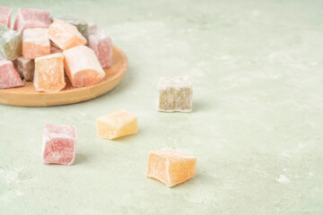 colorful Turkish delights on the plate on green