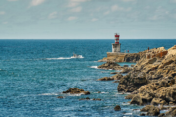 lighthouse on the rocky shore of the ocean