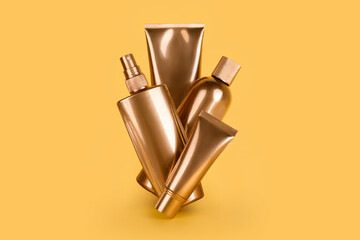 Golden bottles, cosmetic products on yellow background. Luxury beauty style. Gold cosmetic containers. Mockup bottles, cosmetics branding, hair or body care concept. Copy space, empty place for text.