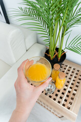 hand holding a glass of orange juice