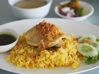 Chicken Biryani food, yellow color Traditional Indian dish of rice and chicken marinated in spices with green sauce