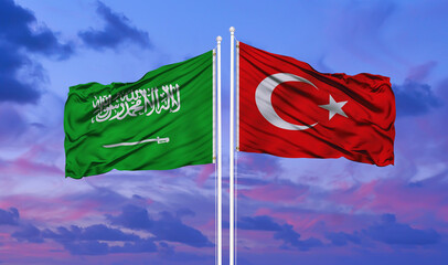 Turkey and Saudi Arabia two flags on flagpoles and blue cloudy sky