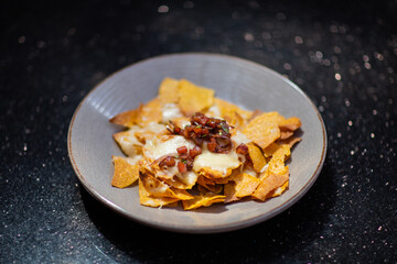 Plate of fresh nachos with a jalapeno, cheese and sauce. Traditional mexican appetizer snack
