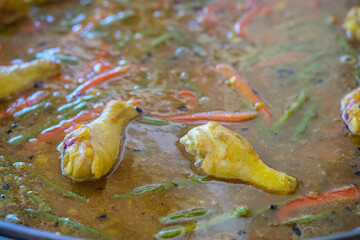 Cooking traditional spanish mixed paella with seafood and chicken in large pot or pan