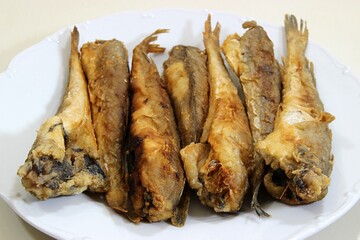 On a plate, fried codling young fish. Close-up with selective focus