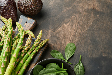 Bunch of fresh green organic asparagus spinach, avocado, chicken eggs and pepper seasoning on black...