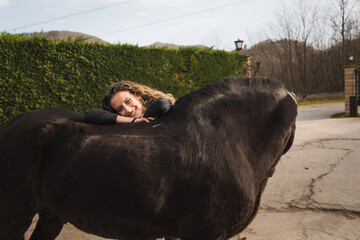 Young caucasian woman with a horse in a equestrian centre