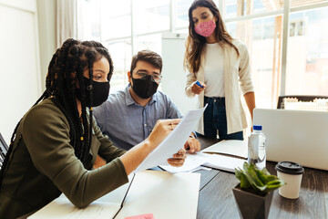 Business team wearing protective masks while meeting in the office during the COVID-19 epidemic