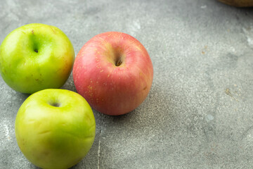 Buah Apel or apples fruits on grey grainy wooden background. Copy space for text and template. 