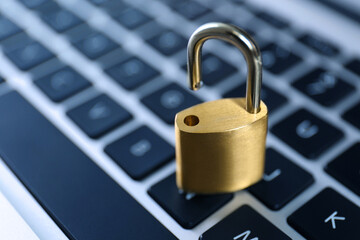 Metal padlock on laptop keyboard, space for text. Cyber security concept