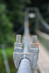Schraubschelle, Rohrschelle mit Muttern und leichtem Rost auf einer Hängebrücke