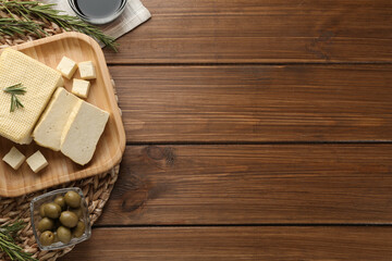 Flat lay with cut tofu on wooden table, space for text. Soya bean curd