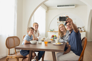 Caucasian family making a selfie or video call at home in breakfast.