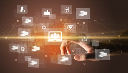 Hand pressing social media multimedia application screen with media icons on futuristic concept