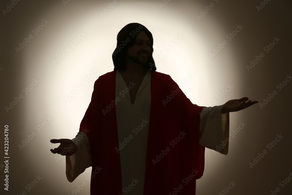 Wall mural Silhouette of Jesus Christ with outstretched arms on color background