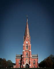 Fototapeta na wymiar The facade and steeple of the brick church Allhelgonakyrkan in Lund Sweden