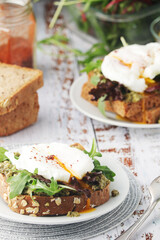 Homemade sandwiches with pesto, green salad and poached eggs