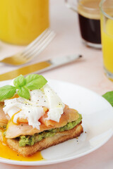 Breakfast with a sandwich with poached egg and avocado