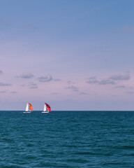 Photography of a summer sea and bright yachts. Blue water and clear sky. Sailboat in the ocean. Tropical climate.