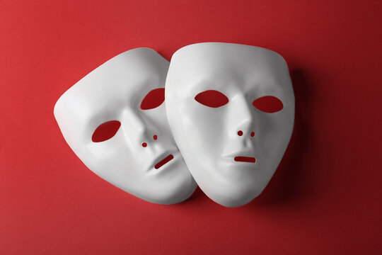 White theatre masks on red background, flat lay