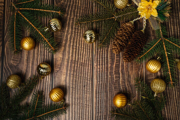 New Year's decor on a wooden background. Fir branches, Christmas balls and wooden toys. Cozy home. Place for the text. View from above