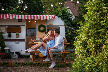 A young brunette man gently kisses a beautiful red-haired girl on the forehead, she laughs....