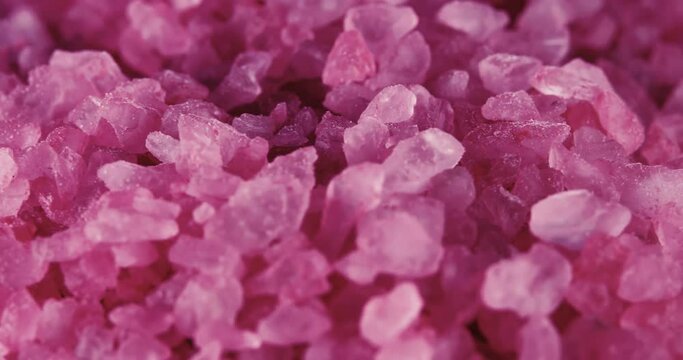 Pink himalayan rock salt as background rotating. Pink Himalayan Salt macro shot. Crystals of pink Himalayan salt float slowly.