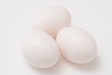 Three white eggs on white background