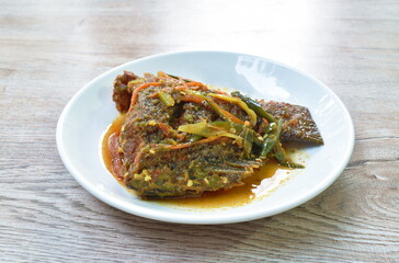 batter fried mango fish tail dressing spicy and sweet sauce on plate