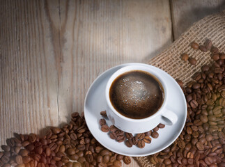 Coffee cup with coffee beans on the table. Beverage background 