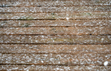 Falling snowflakes makes a pretty splattered pattern on the backyard deck in southwest Missouri on a winter day. The snow was still falling as this photograph was taken. Bokeh effect