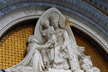 Detail of the sculptures above the entrance doors to the Sacred Basilica of Lourdes, important places of pilgrimage for the Catholic religion