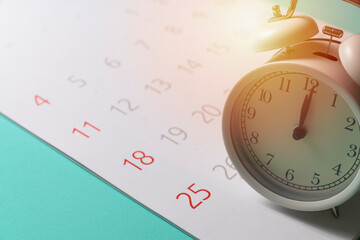 close up of calendar and alarm clock on the green table background, planning for business meeting...
