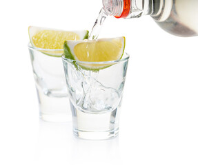strong alcohol pouring into shot glasses